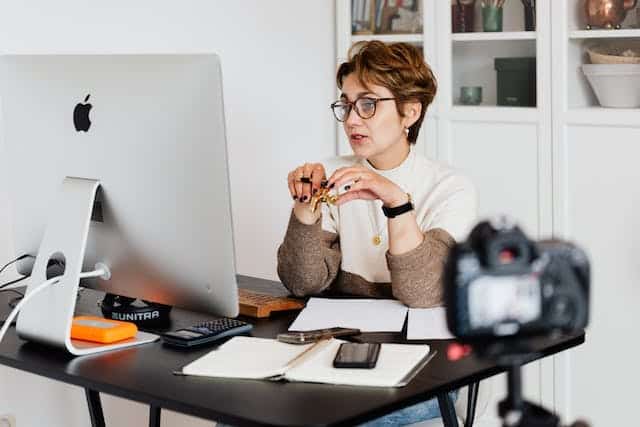 filming woman sitting at desk