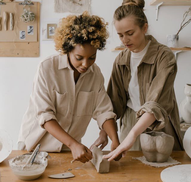 two women cutting clay