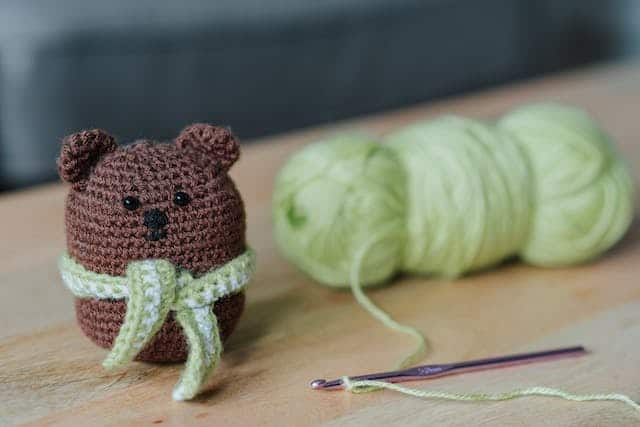 crocheted teddy bear and yarn